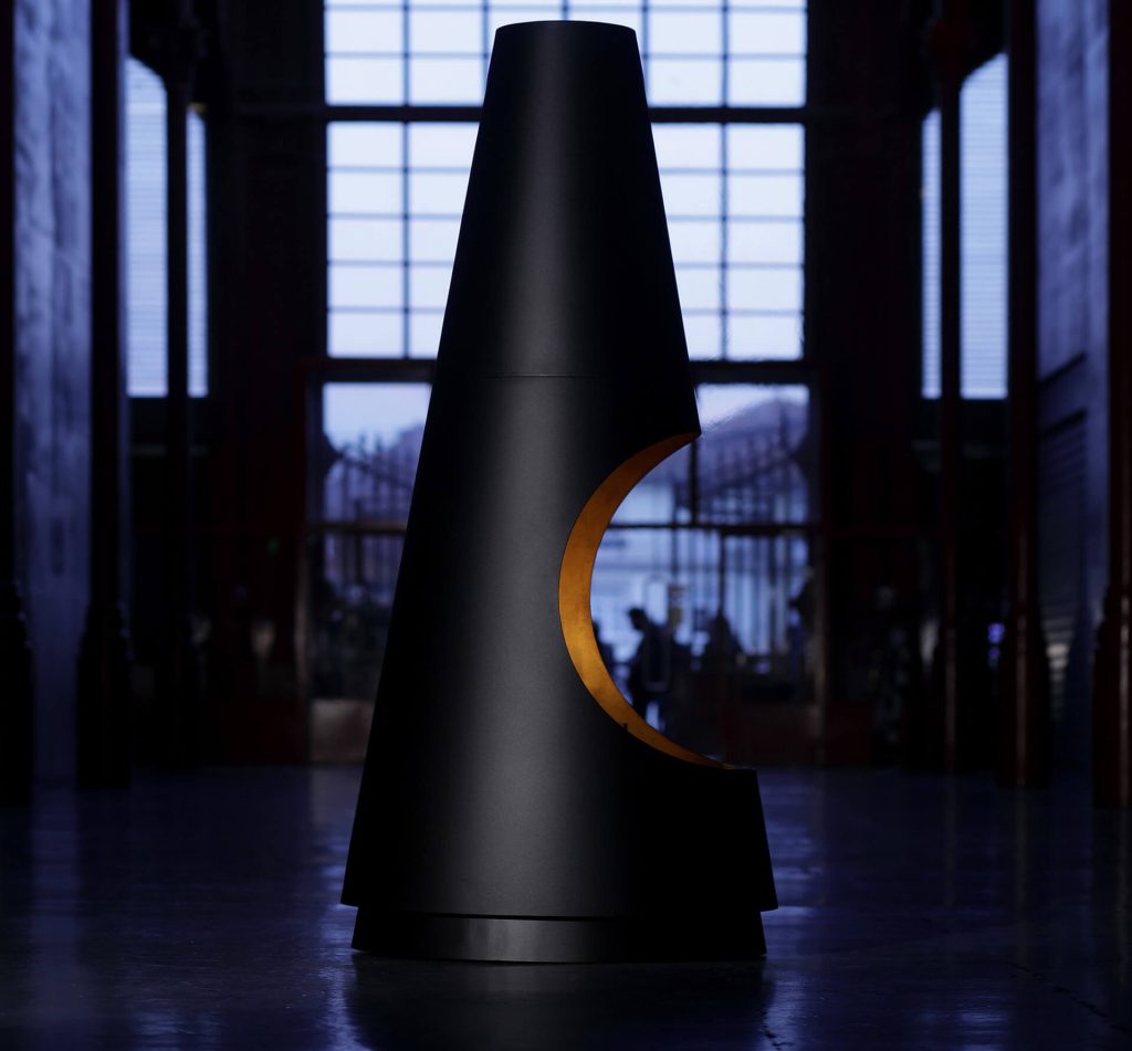 Side view of Archimedes bioethanol fireplace by GlammFire with black and gold design in a dark minimalist setting