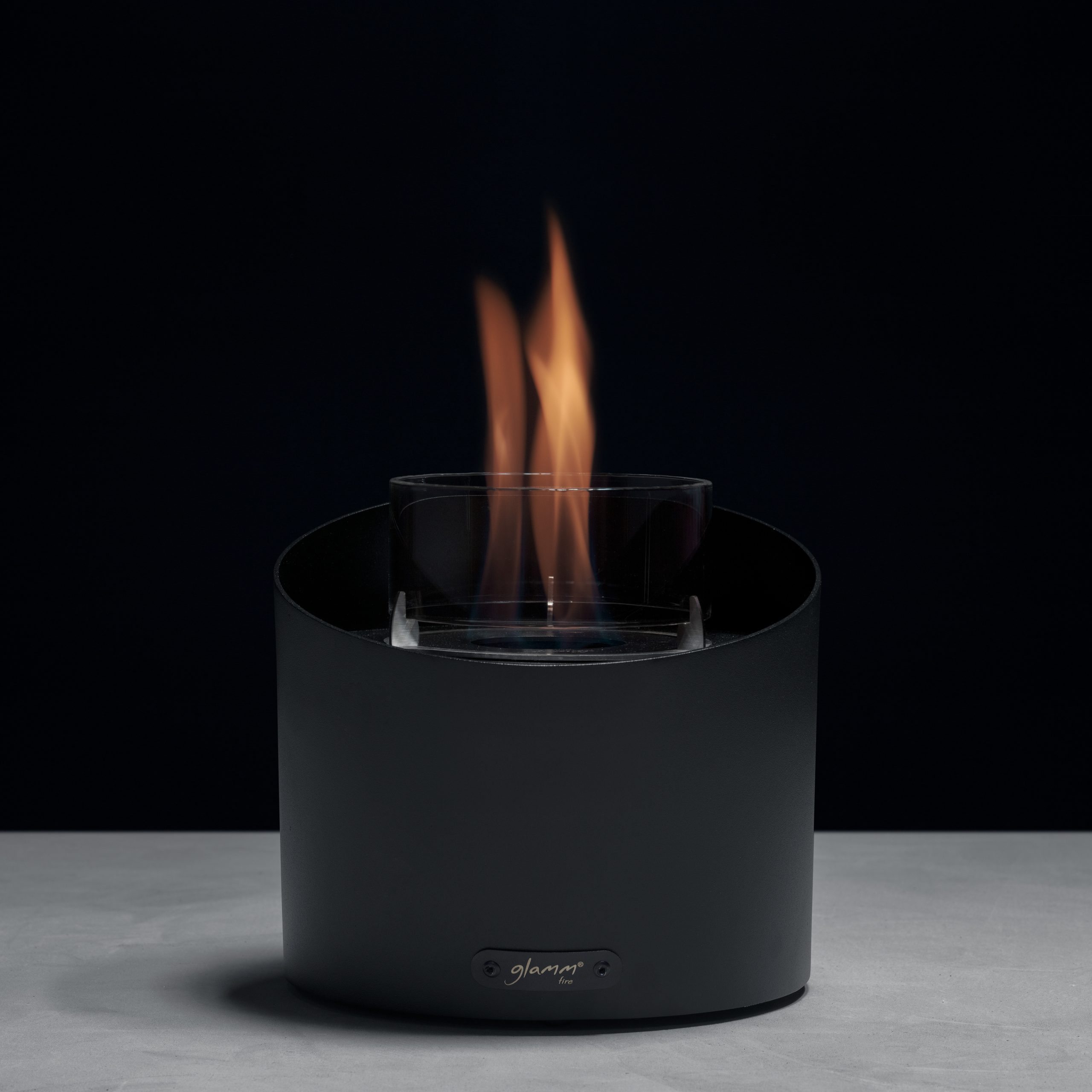 Contour tabletop bioethanol fireplace displayed in a studio setting, showcasing its modern design and functionality.