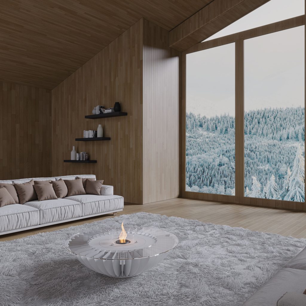 Cosmo EVO Round bioethanol fireplace by GlammFire in a modern living room with a snowy forest view, offering warmth and contemporary design.