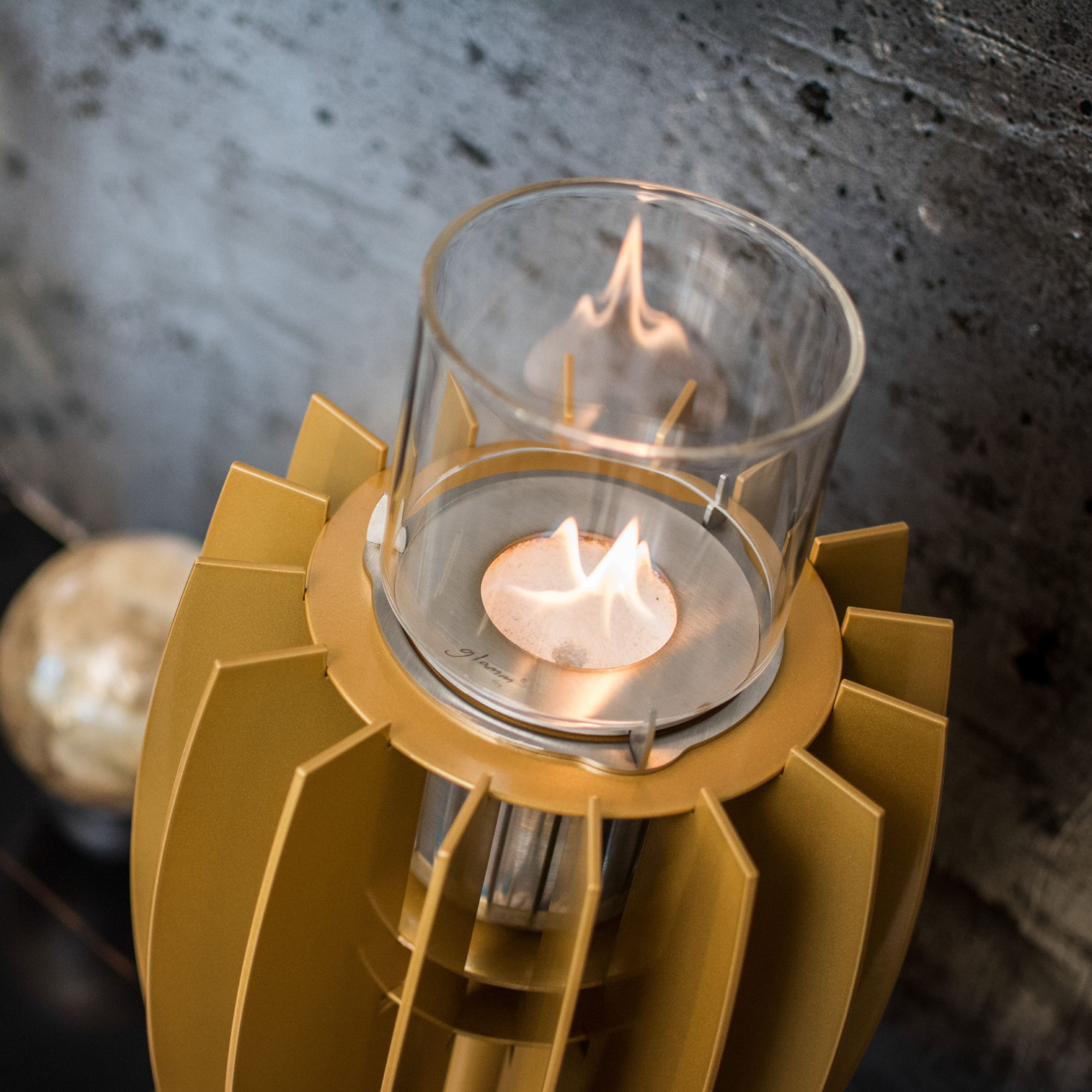 Elegant golden Tuli tabletop bioethanol fireplace, perfect for modern luxury interiors.