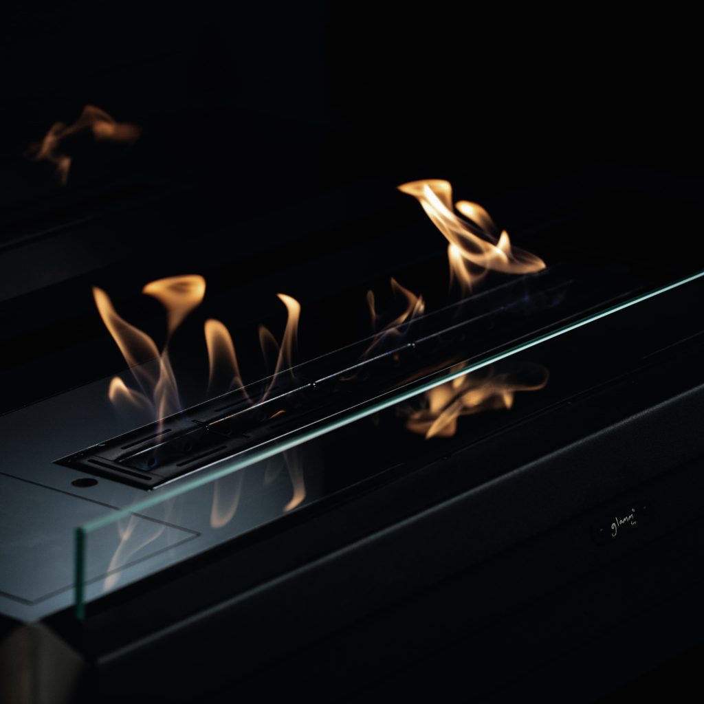 Close-up of the York bioethanol fireplace flames with a sleek glass enclosure by GlammFire.