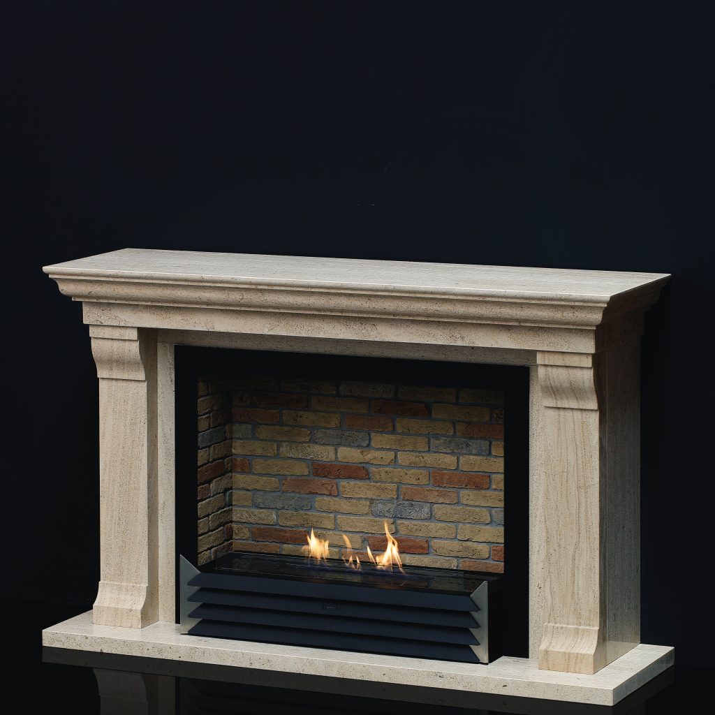York bioethanol fireplace insert with a brick-lined background, encased in a classic stone mantel by GlammFire.