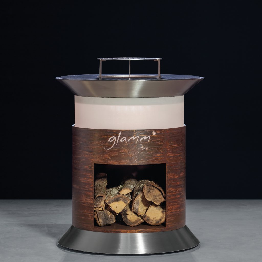 Close-up of Alba Grill by GlammFire, featuring a circular design with a fire pit and wood storage, perfect for outdoor cooking and entertaining.