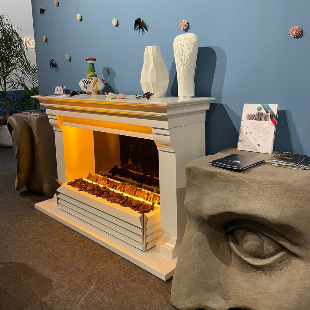 York electric fireplace by GlammFire in a modern showroom setting, showcasing a clean white mantel with warm, glowing flames, surrounded by contemporary decor elements.