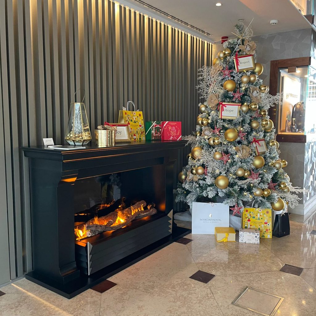 York electric fireplace by GlammFire in a festive environment with a Christmas tree and holiday decor, adding warmth and charm to the seasonal ambiance.