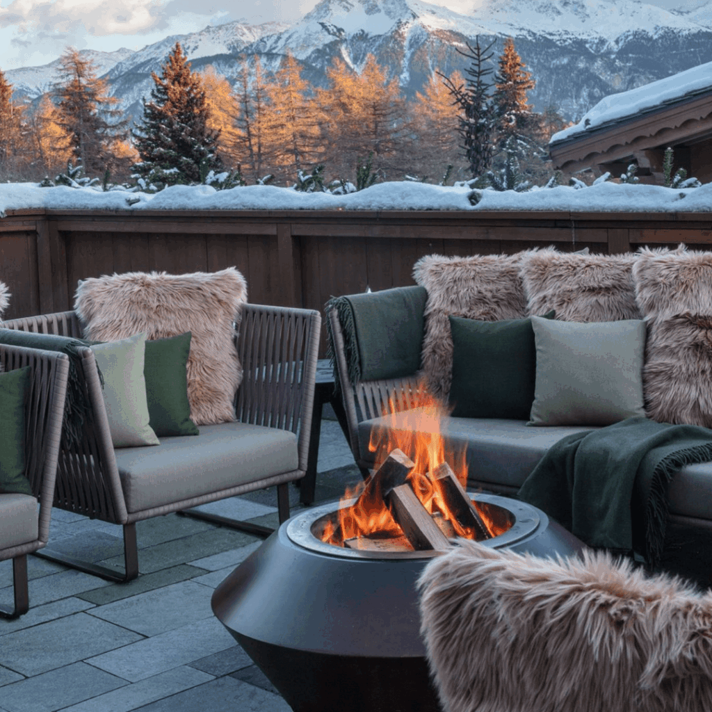 Operetta outdoor fire pit by GlammFire on a luxury alpine terrace surrounded by snow-covered mountains