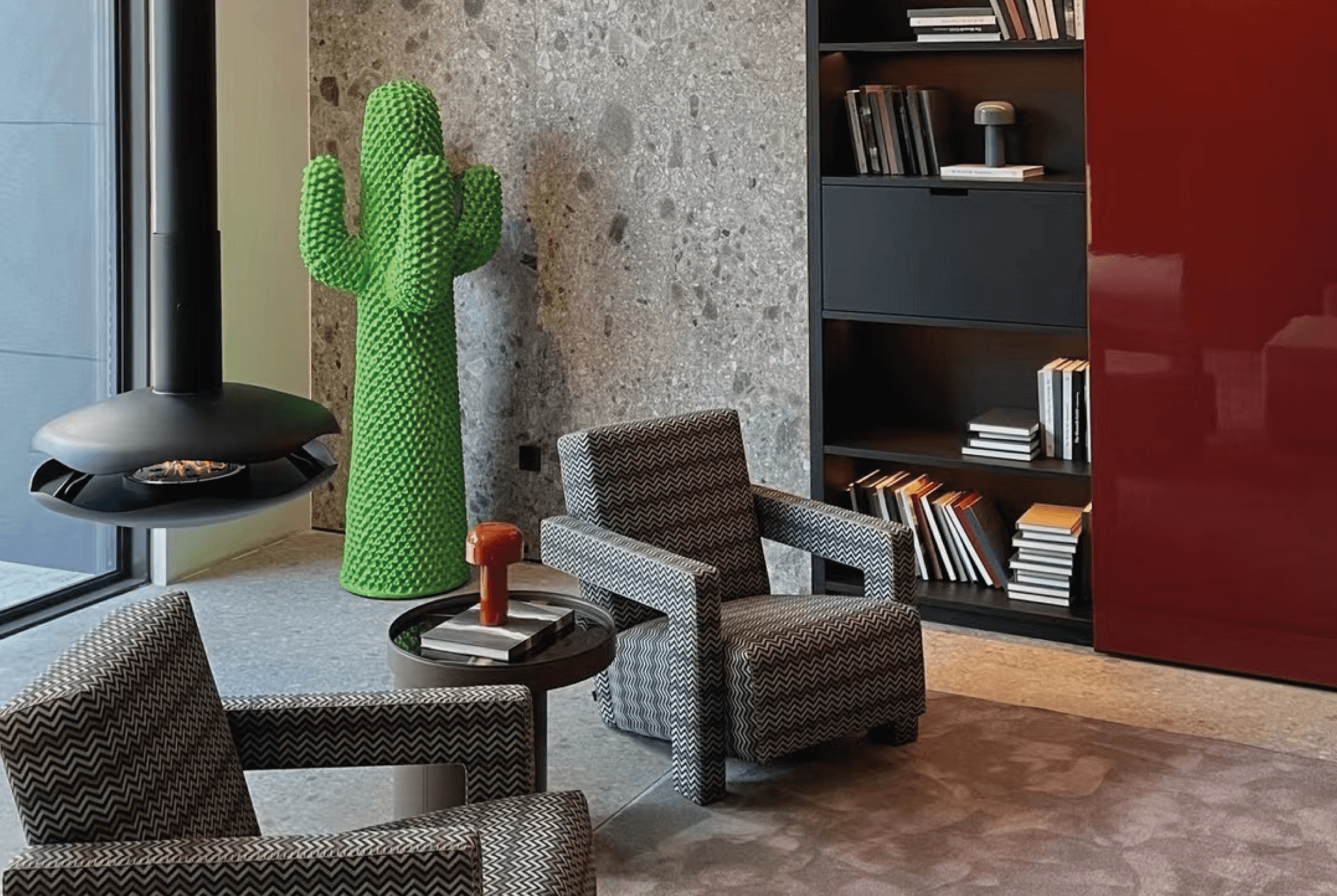 Perola suspended bioethanol fireplace with black lacquer finish and marine-inspired design in a modern living room with chairs and bookshelves