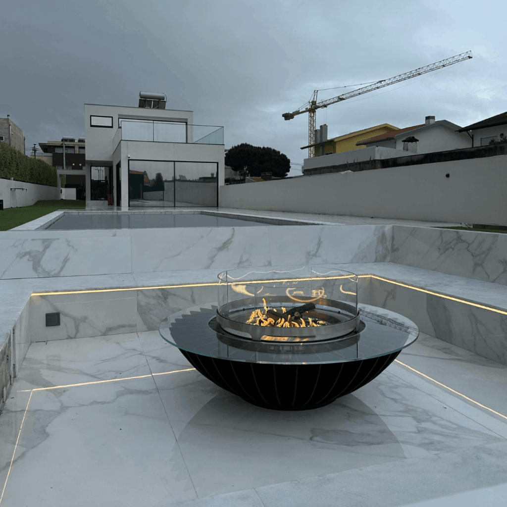 Cosmo gas fire pit by GlammFire in a contemporary outdoor space with pool and architectural surroundings