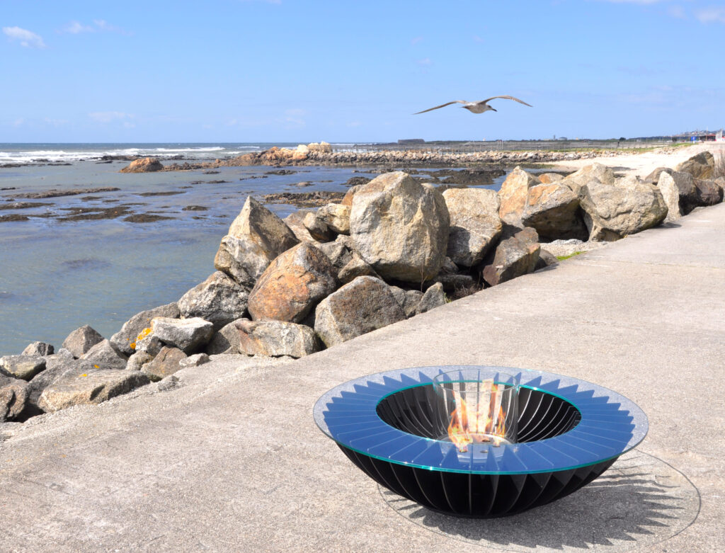 Lareira Cosmo 13 preta a bioetanol da GlammFire em ambiente exterior junto ao mar.