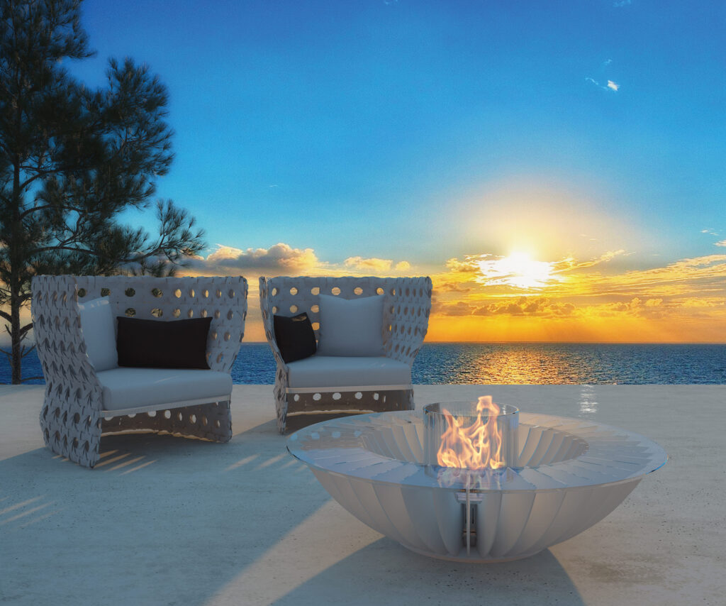 Lareira Cosmo 13 branca a bioetanol da GlammFire em terraço exterior com vista para o mar ao pôr do sol.