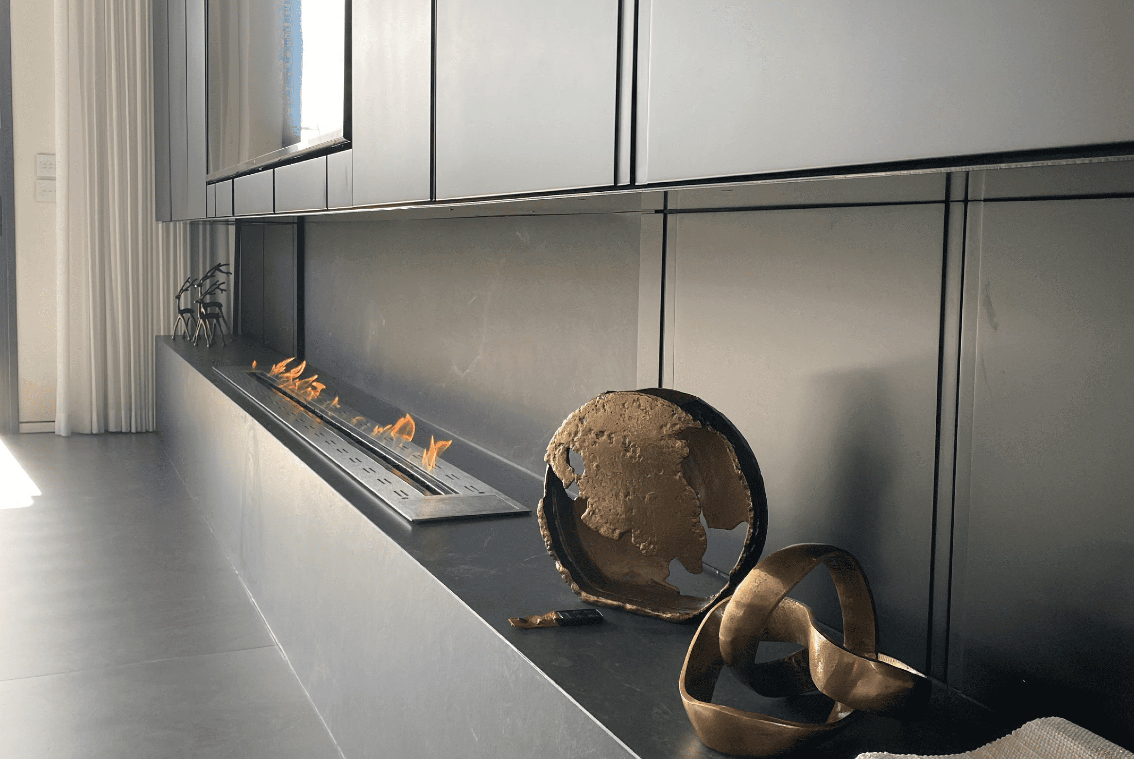 Fire Line bioethanol fireplace integrated into a modern minimalist living space with contemporary sculptures