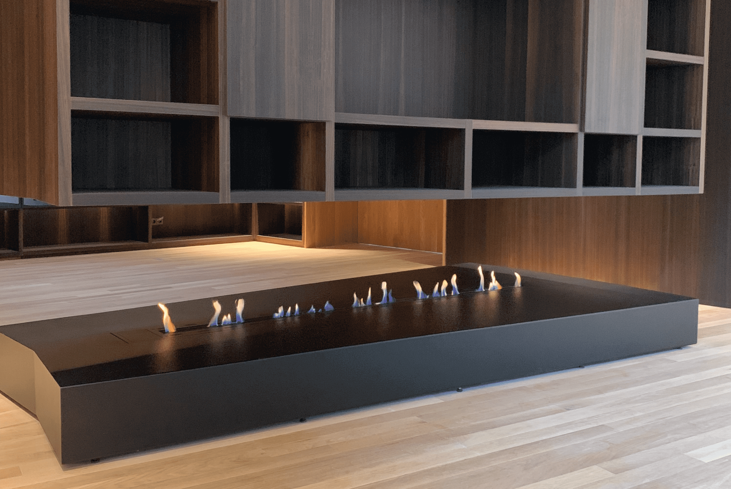 Fire Line bioethanol fireplace integrated into a modern open-space wooden interior by GlammFire