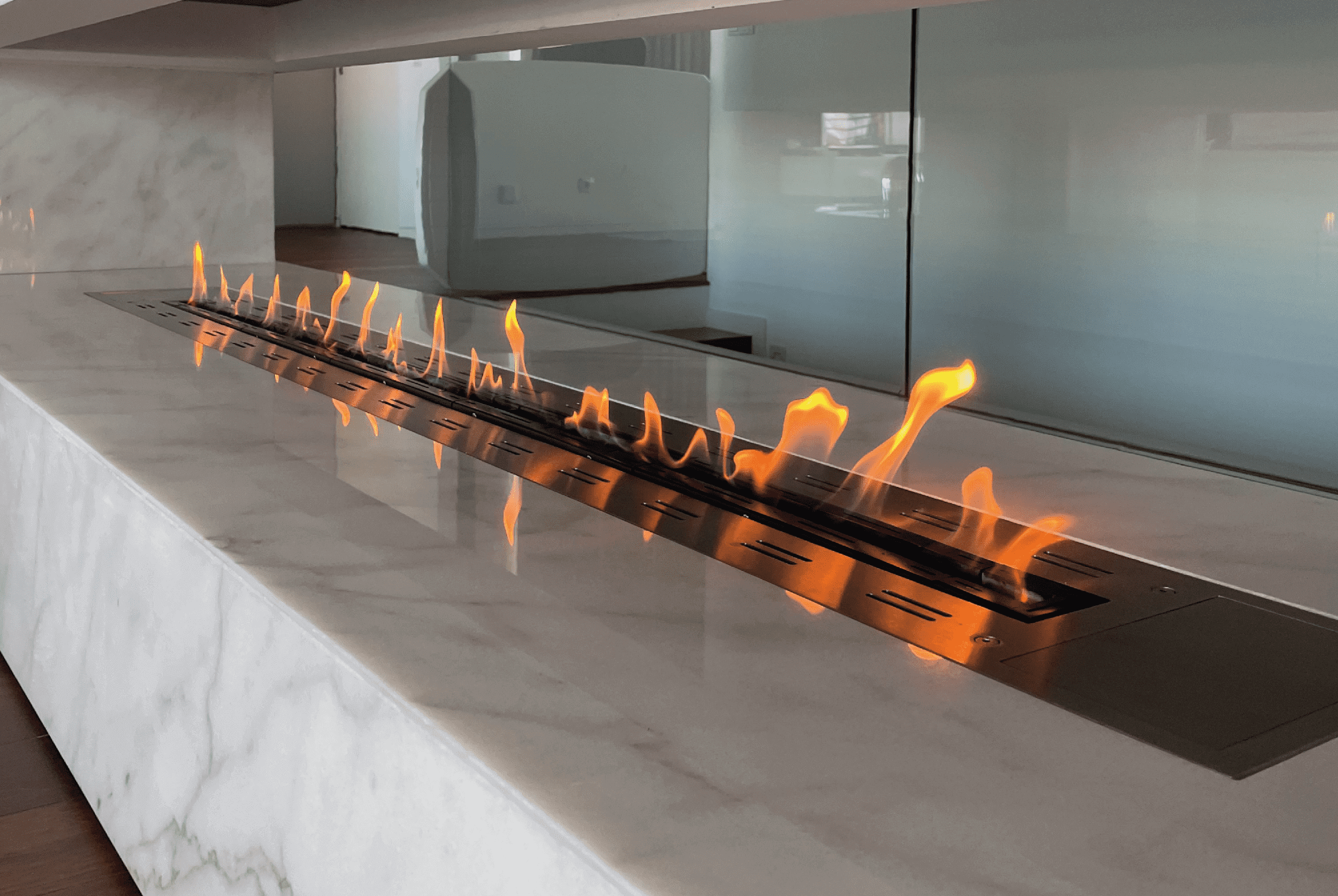 Fire Line bioethanol burner by GlammFire integrated into a modern marble fireplace