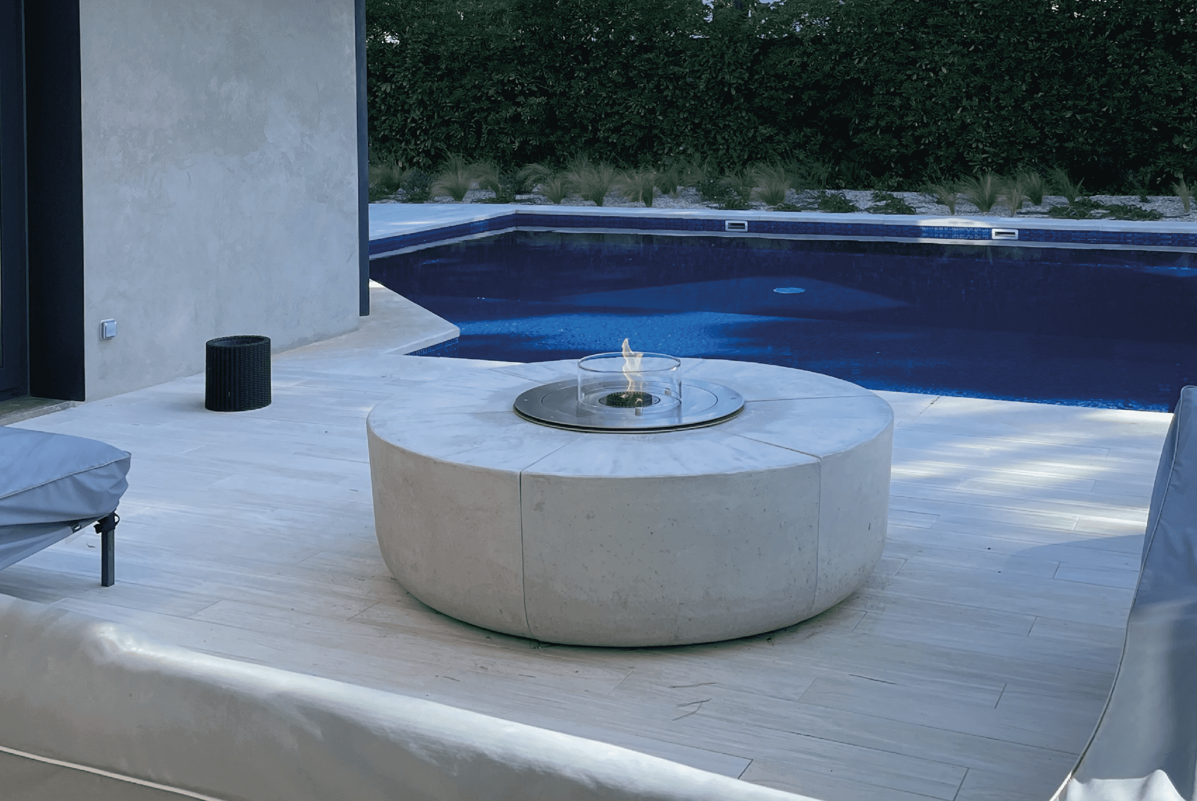 Modern bioethanol fire pit by GlammFire next to a swimming pool in a contemporary outdoor space
