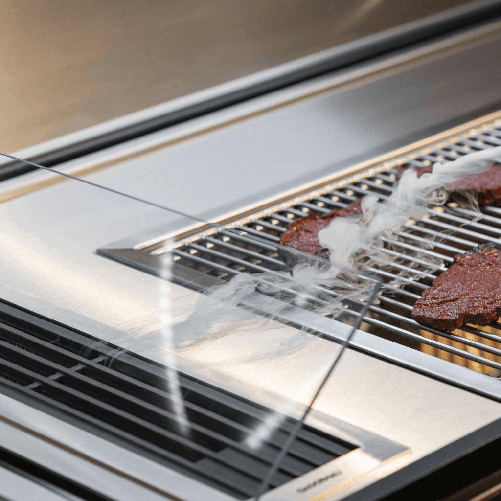 Fortezza outdoor kitchen grill detail with smoke extraction system and stainless steel cooking surface