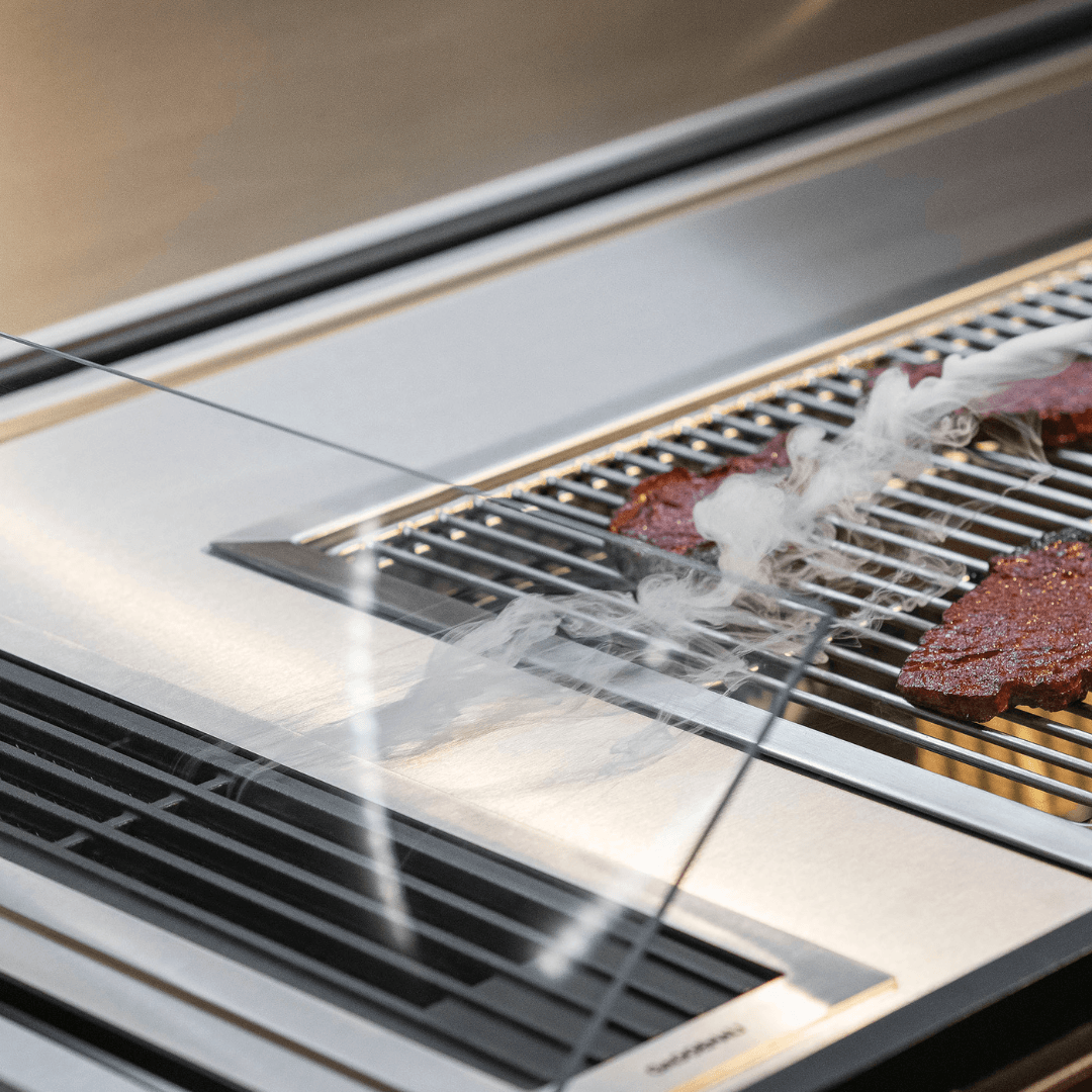 Fortezza outdoor kitchen grill detail with smoke extraction system and stainless steel cooking surface