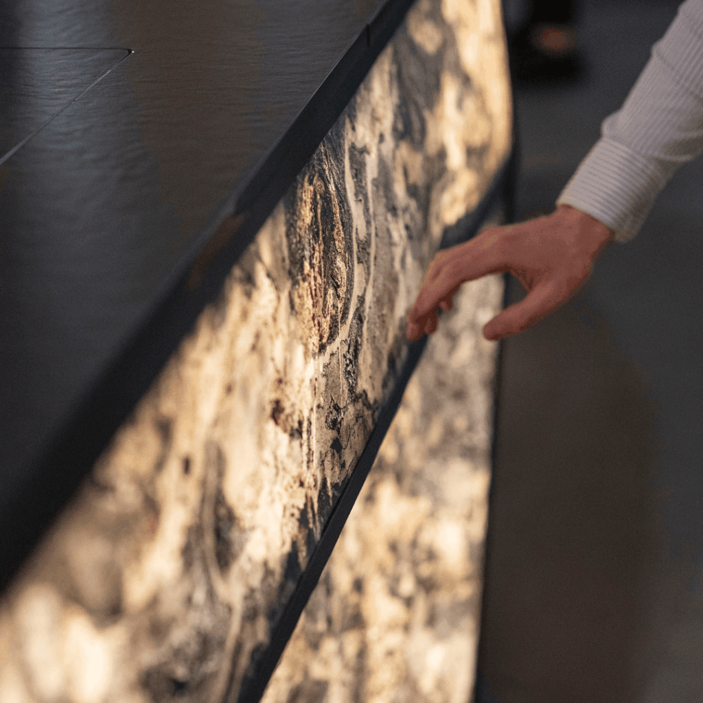 Close-up of Concept outdoor kitchen illuminated stone surface with hand detail by GlammFire