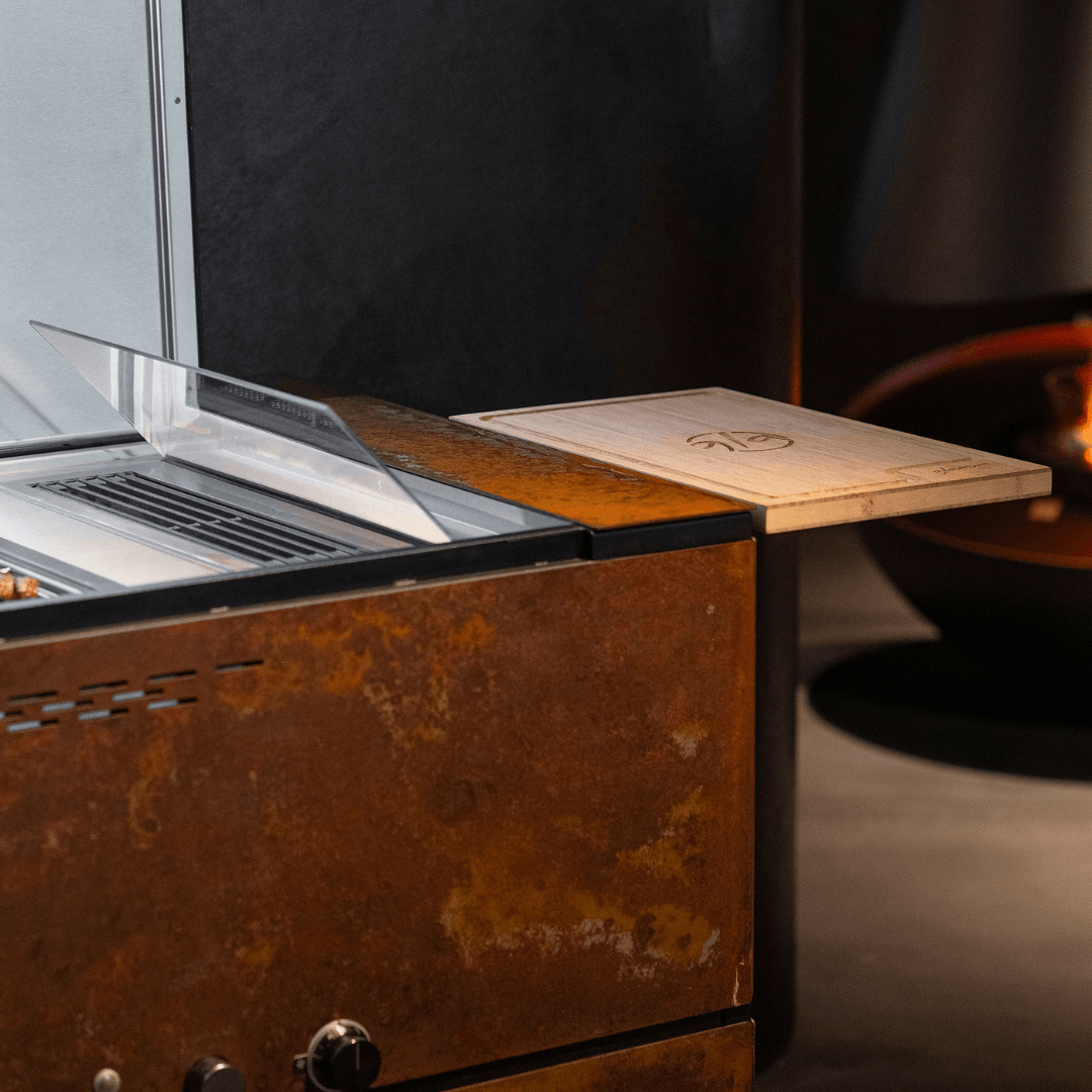 Fortezza outdoor kitchen side detail with wooden preparation board, glass shield and textured metal finish