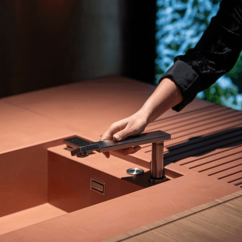 Hand operating the integrated tap on the Brezza outdoor kitchen by GlammFire