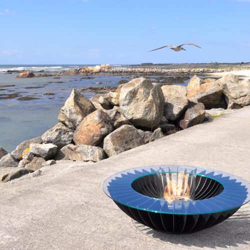 Lareira Cosmo 13 preta a bioetanol da GlammFire em ambiente exterior junto ao mar.