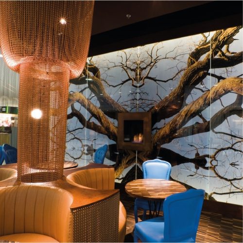 Lotus bioethanol wall fireplace in a luxurious restaurant setting with tree mural by GlammFire