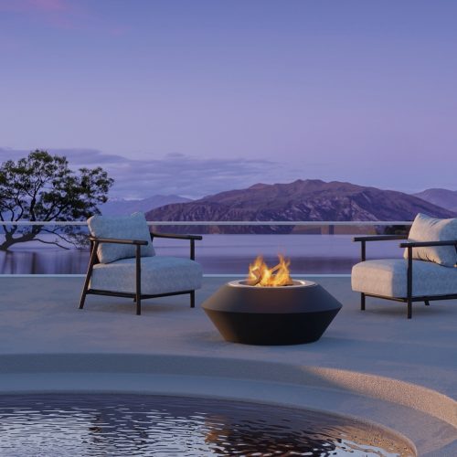 Operetta firewood fire pit in a scenic outdoor setting overlooking mountains and water.