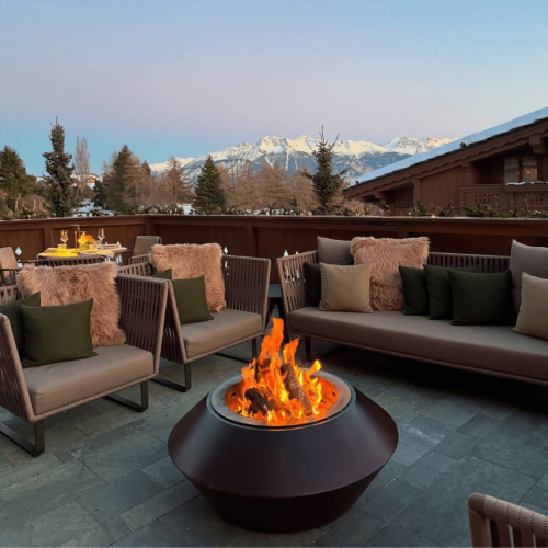 Operetta outdoor fire pit by GlammFire on a luxury alpine terrace surrounded by snow-covered mountains