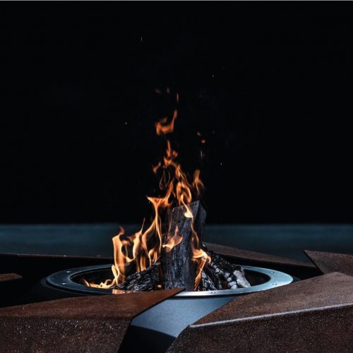 Close-up of Stravaganza fire pit by GlammFire with modern geometric design and roaring fire