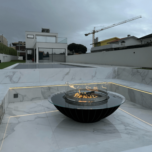 Cosmo gas fire pit by GlammFire in a contemporary outdoor space with pool and architectural surroundings